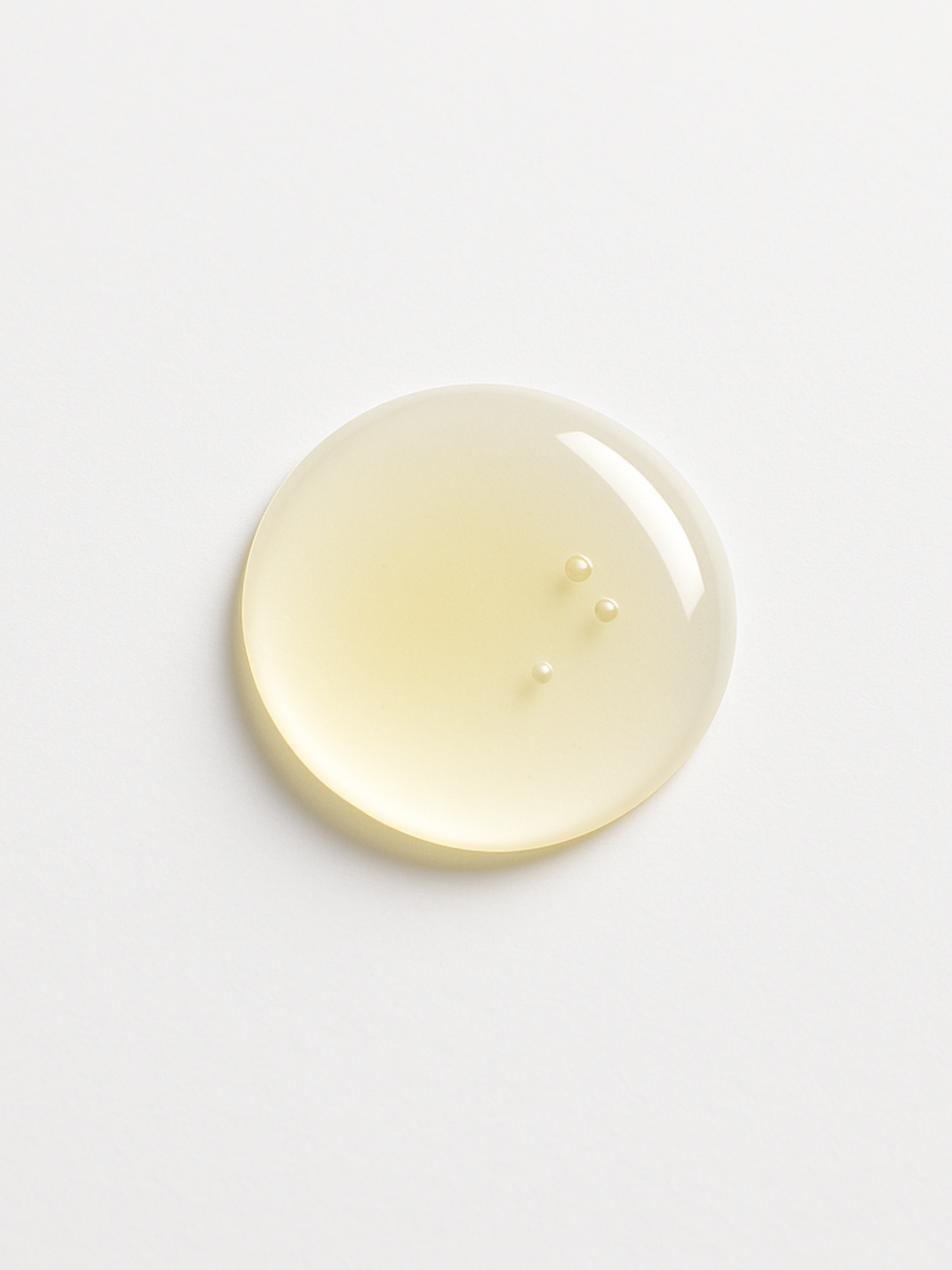 Texture du sérum OxiShield d’Unlëss Cosmetics déposée en goutte sur fond blanc.