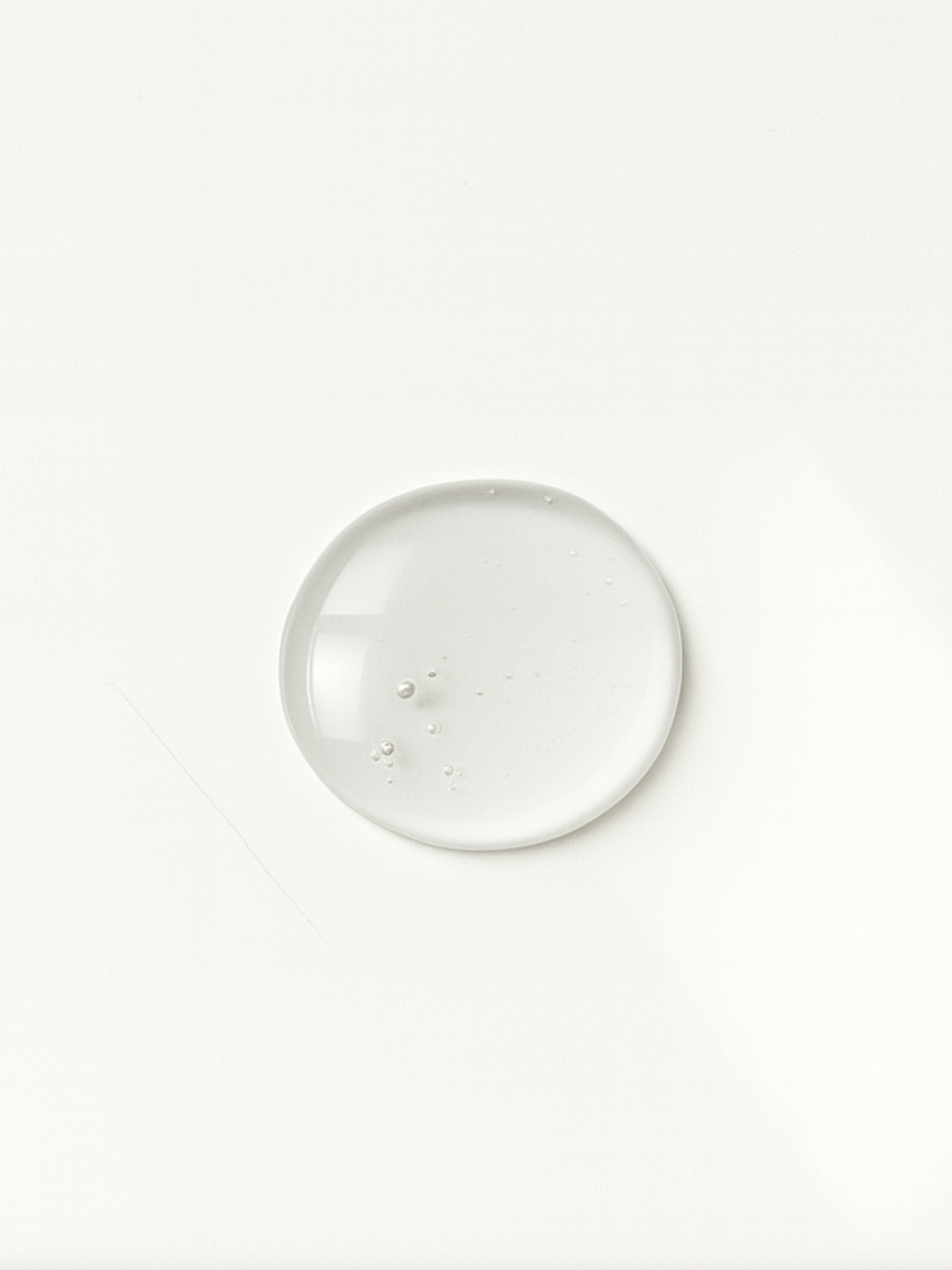 Texture du sérum ClarityBoost d’Unlëss Cosmetics déposée en goutte sur fond blanc.